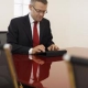 Businessman in a suit working on a tablet in a conference room