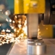 Close-up of a machine tool cutting metal with sparks flying in a factory