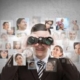 Businessman with binoculars analyzing faces in a digital network, symbolizing talent search and recruitment